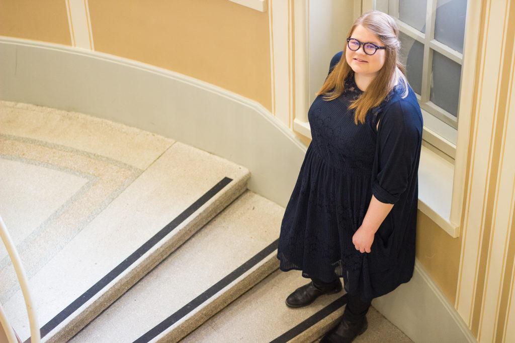 Yläviistosta otettu kuva Jane Kärnästä, joka seisoo Uuden ylioppilastalon portakoissa. Hänen jaloissaan näkyvät portaisiin vasta teipatut uudet kontrastiteipit.