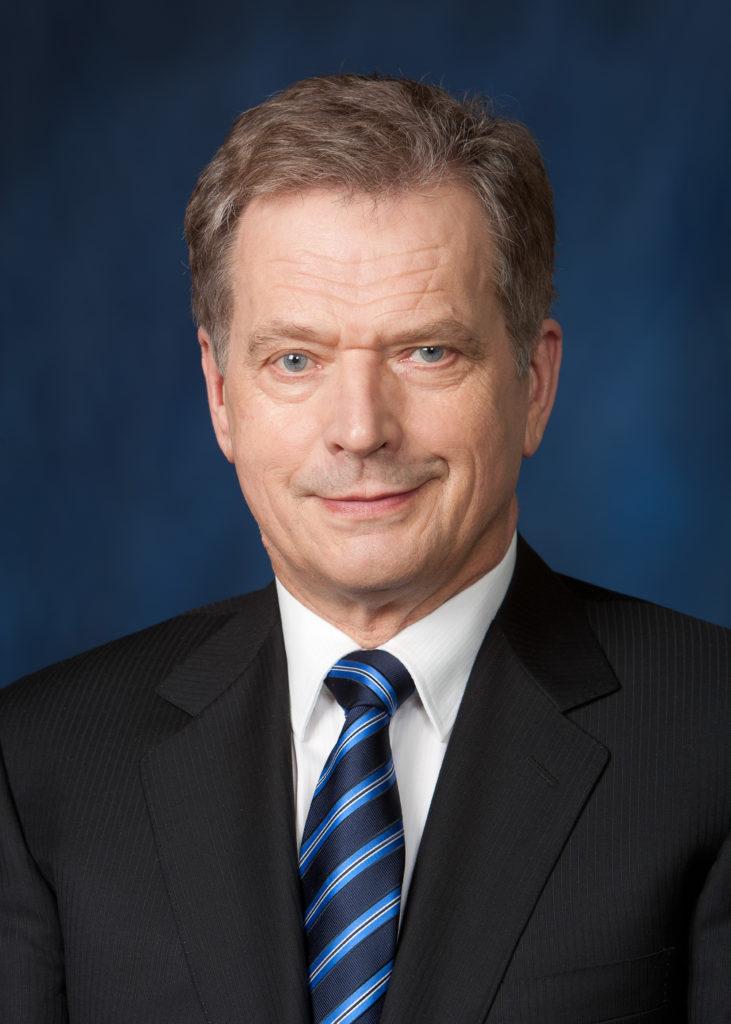 Tasavallan presidentti Sauli Niinistö. Hänellä on ruskeat hiukset, tumma puvuntakki, valkoinen paita ja siniraidallinen solmio.