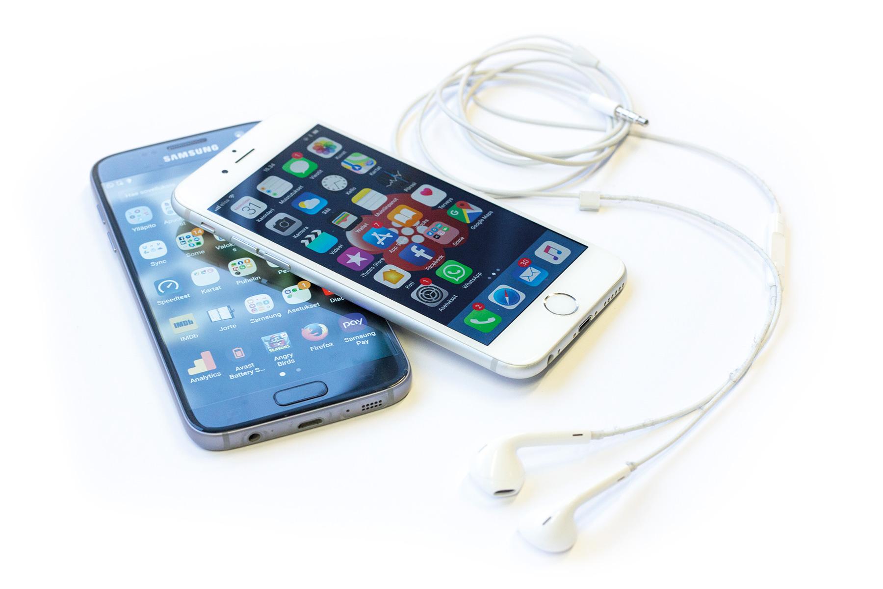 Samsung Galaxy S7 ja Apple iPhone 6 -puhelimet pöydällä