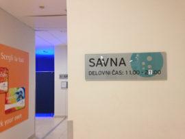 Seinässä kyltti, jossa lukee Savna ja aukioloajat slovenian kielellä.
