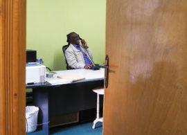 Abebe Yehualawork istuu toimistossaan puhumassa puhelimessa.