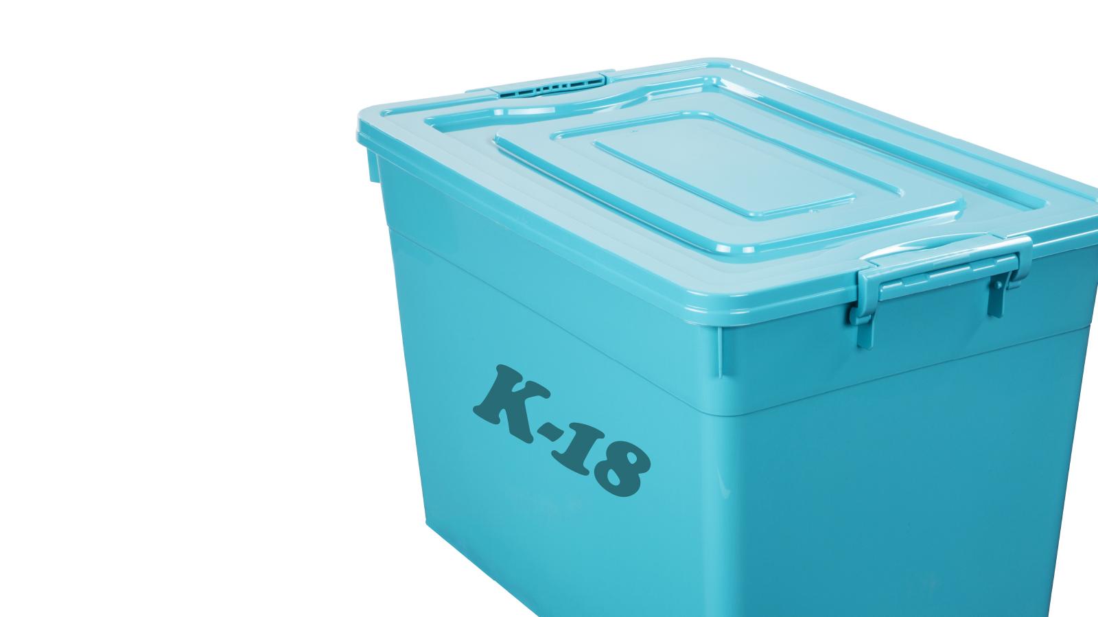 Turkoosi kannellinen muovilaatikko, jossa teksti K-18.