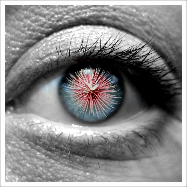 Lähikuva ihmisen silmästä, josta heijastuu ilotulitemaiset värit.