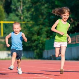 Lapset juoksevat urheilukentällä.