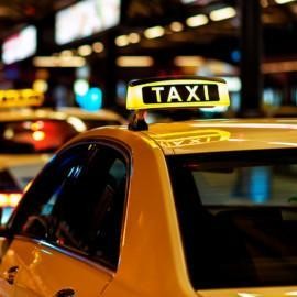 Keltainen taksi, jonka katolla Taxi-kyltti.