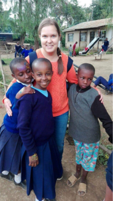 Nuori nainen kolmen tansanialaisen lapsen kanssa.